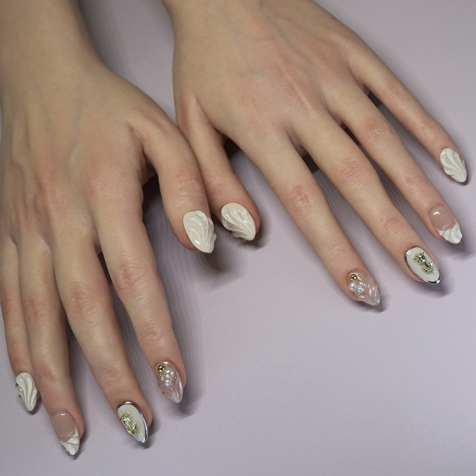 Model wearing Rosewater Shell press-on nails in a cozy neutral-toned outfit, showcasing soft sculpted designs in natural light.