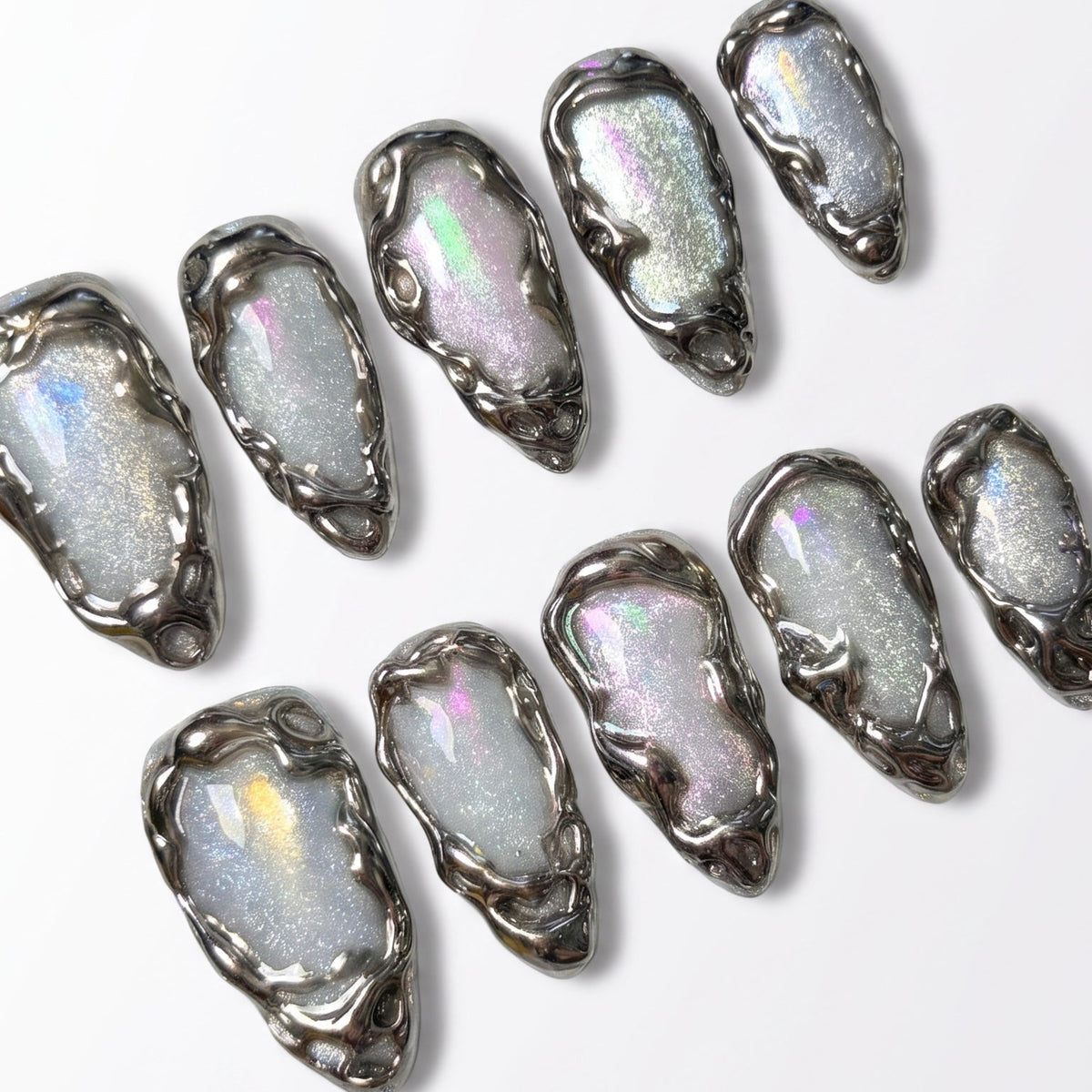 Close-up of handmade pearl press-on nails featuring organic liquid chrome borders and glossy finish.