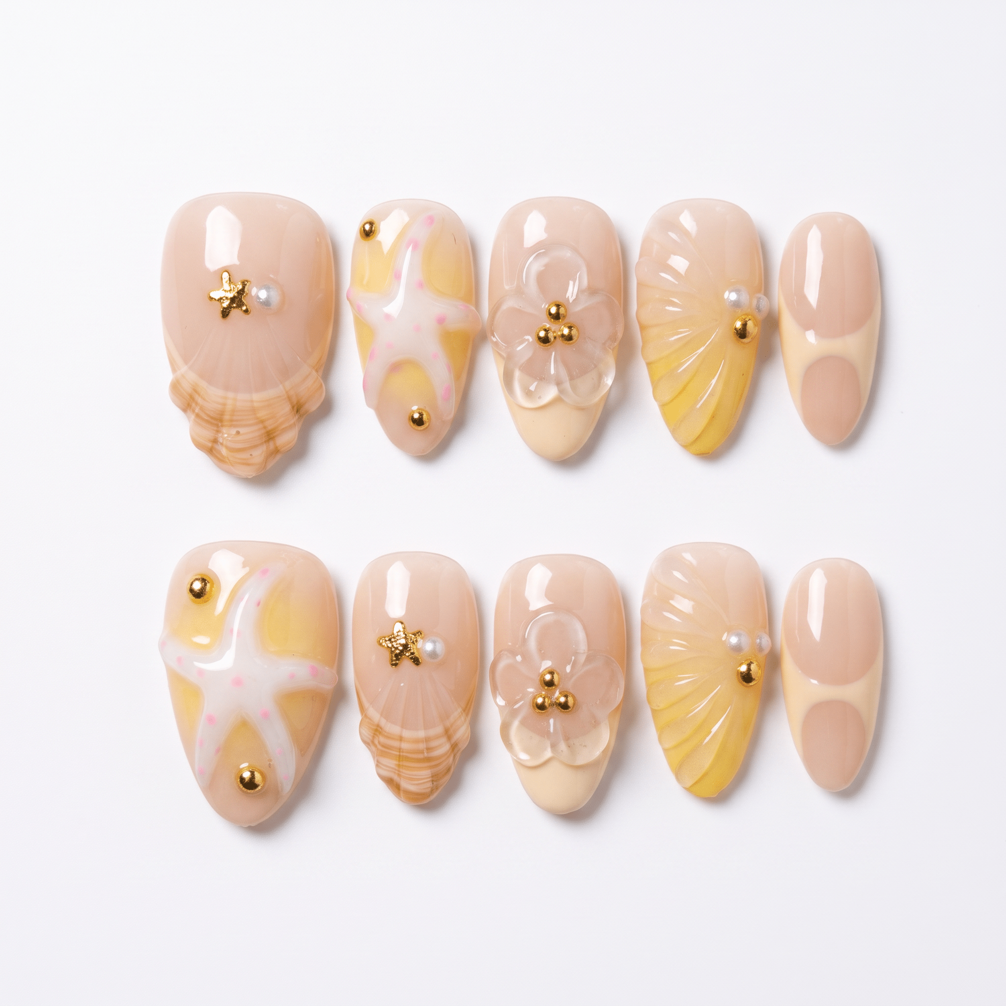 Handmade summer press-on nails featuring 3D seashells, starfish, butter yellow details, flowers, pearls, and glossy finish.
