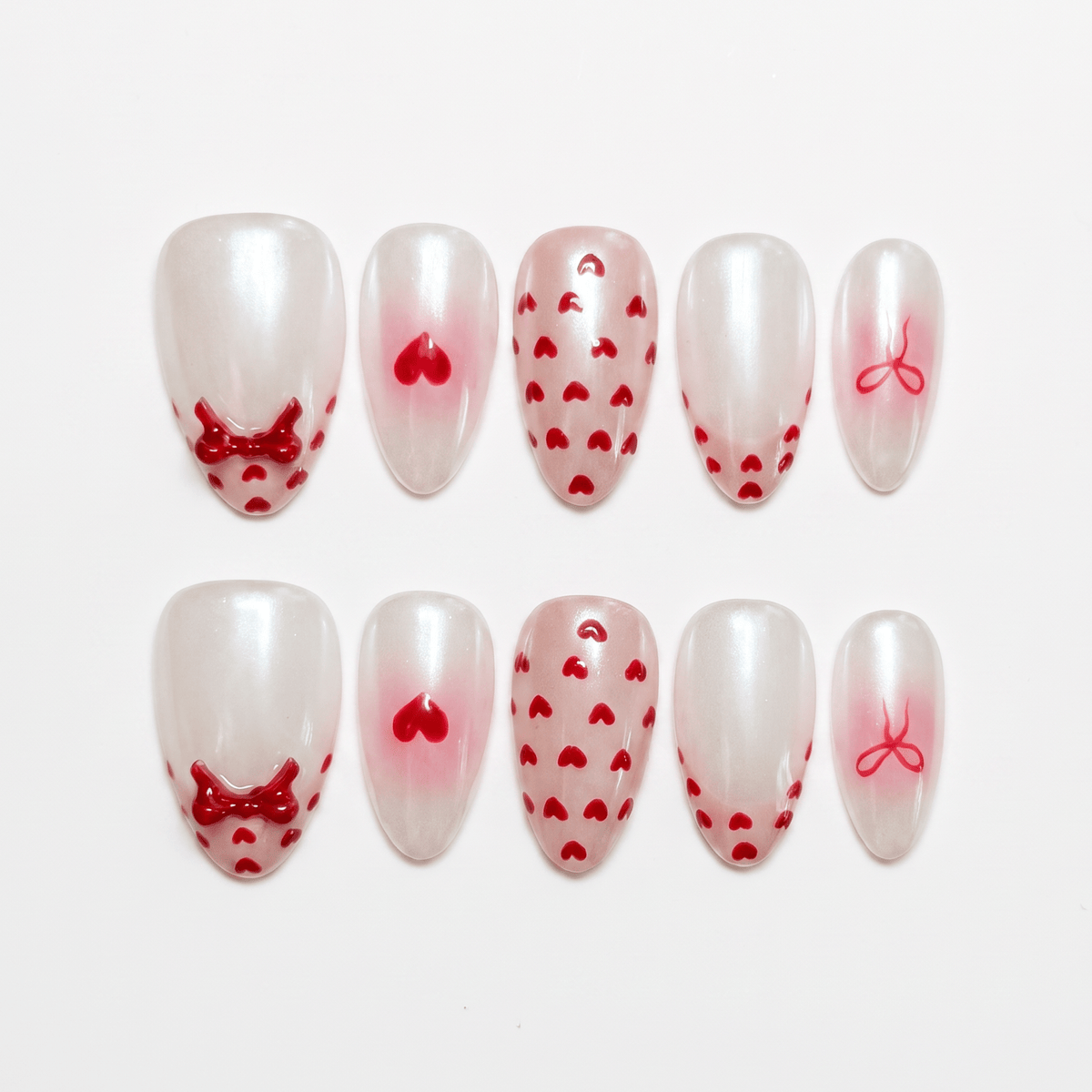 Goat zodiac press-on nails in milky white with red heart and bow details, representing Serene self love and emotional calm.