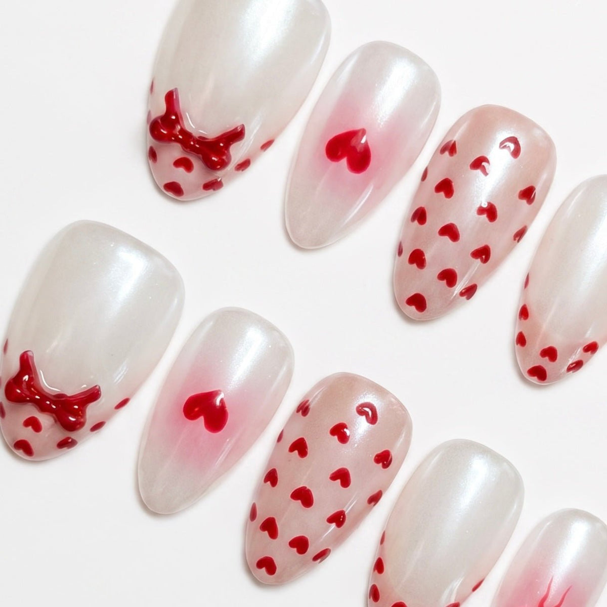 Detail view of Goat zodiac Valentine nails showing soft pink blush gradients, heart motifs, and balanced almond shape.