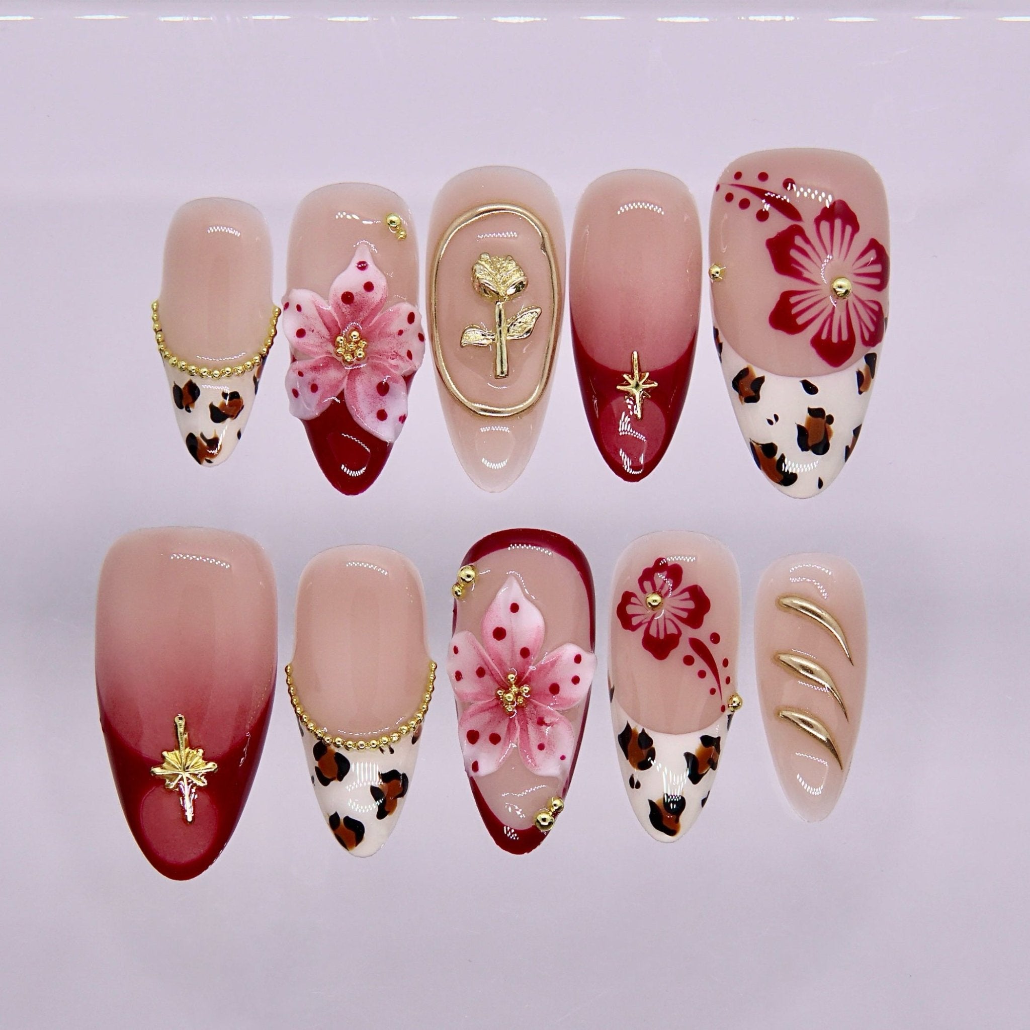 Red gradient press on nails with floral design, leopard print accents, and gold details