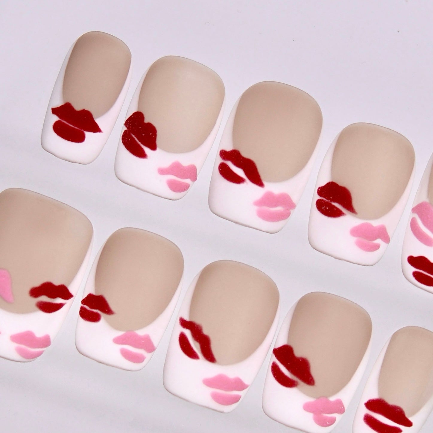 Detail view of Valentine inspired Monkey zodiac nails with playful lip patterns and smooth almond shape.