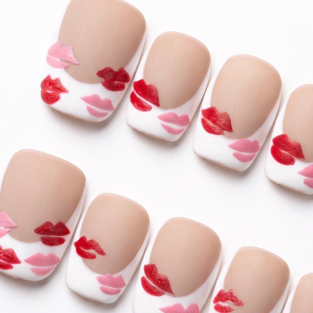 Close-up of Monkey Sparkle press-on nails featuring glossy red and pink lip accents on a soft nude matte base.
