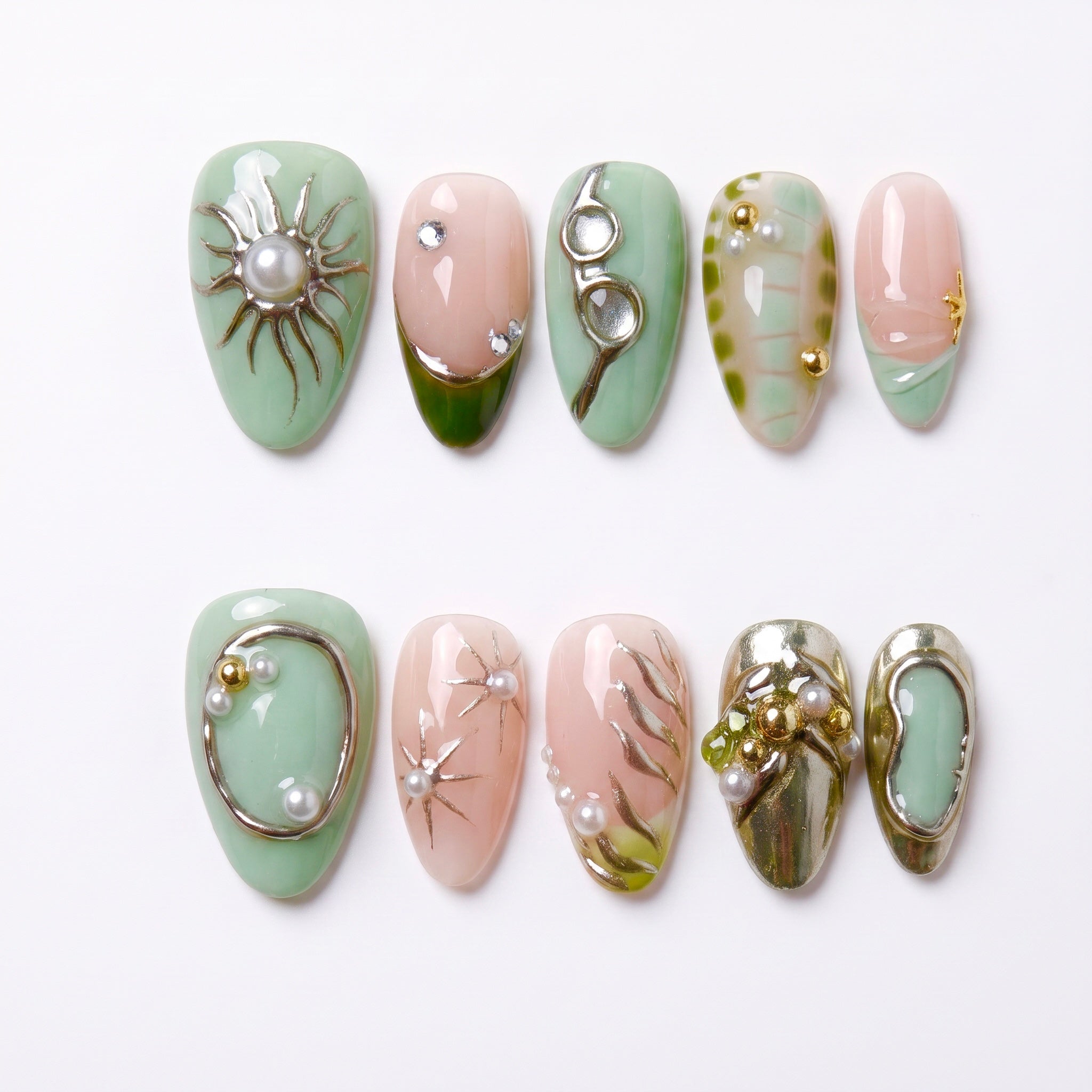 Olive green and nude press-on nails with golden starburst details.