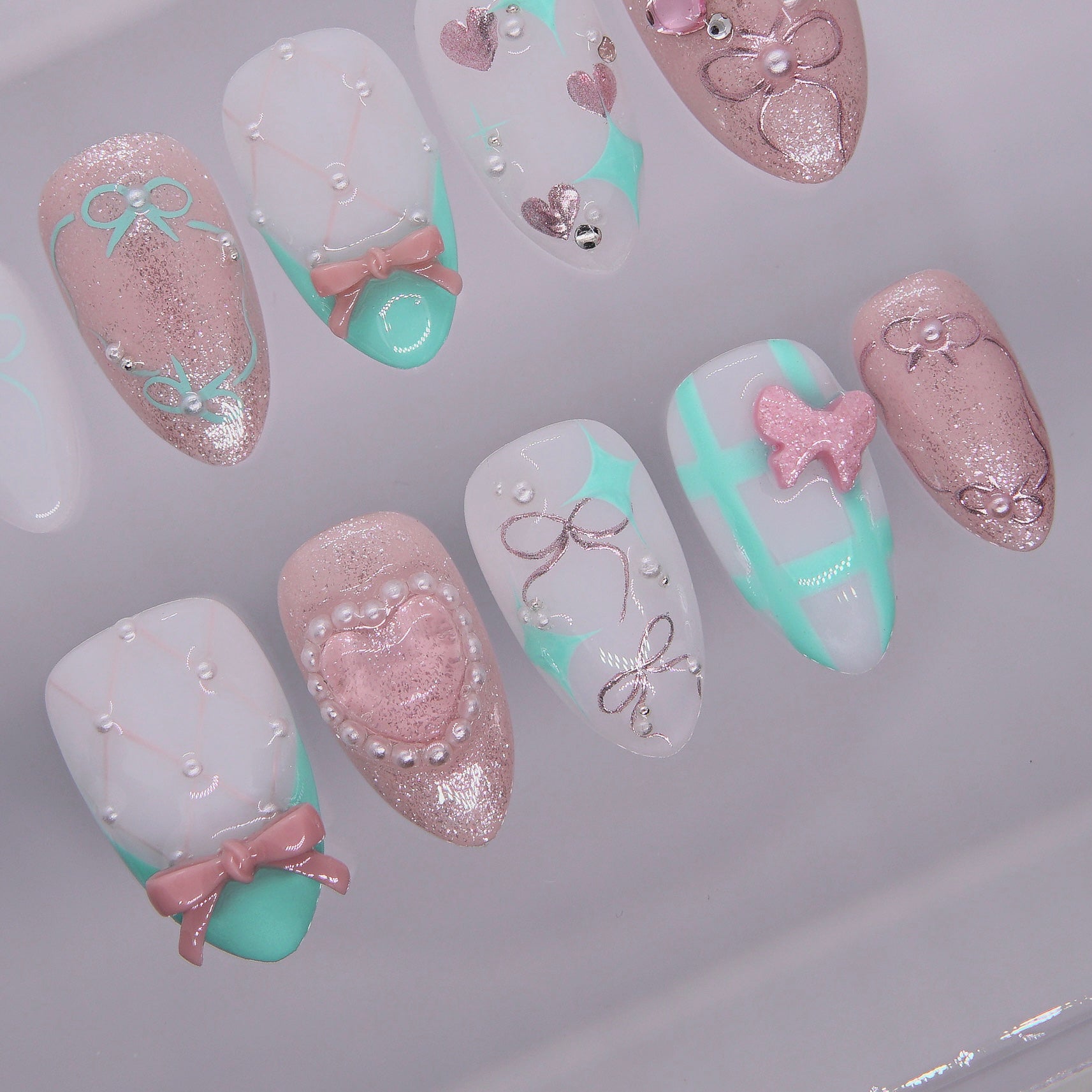 Mint checkerboard nail with pink butterfly charm and shimmer finish.