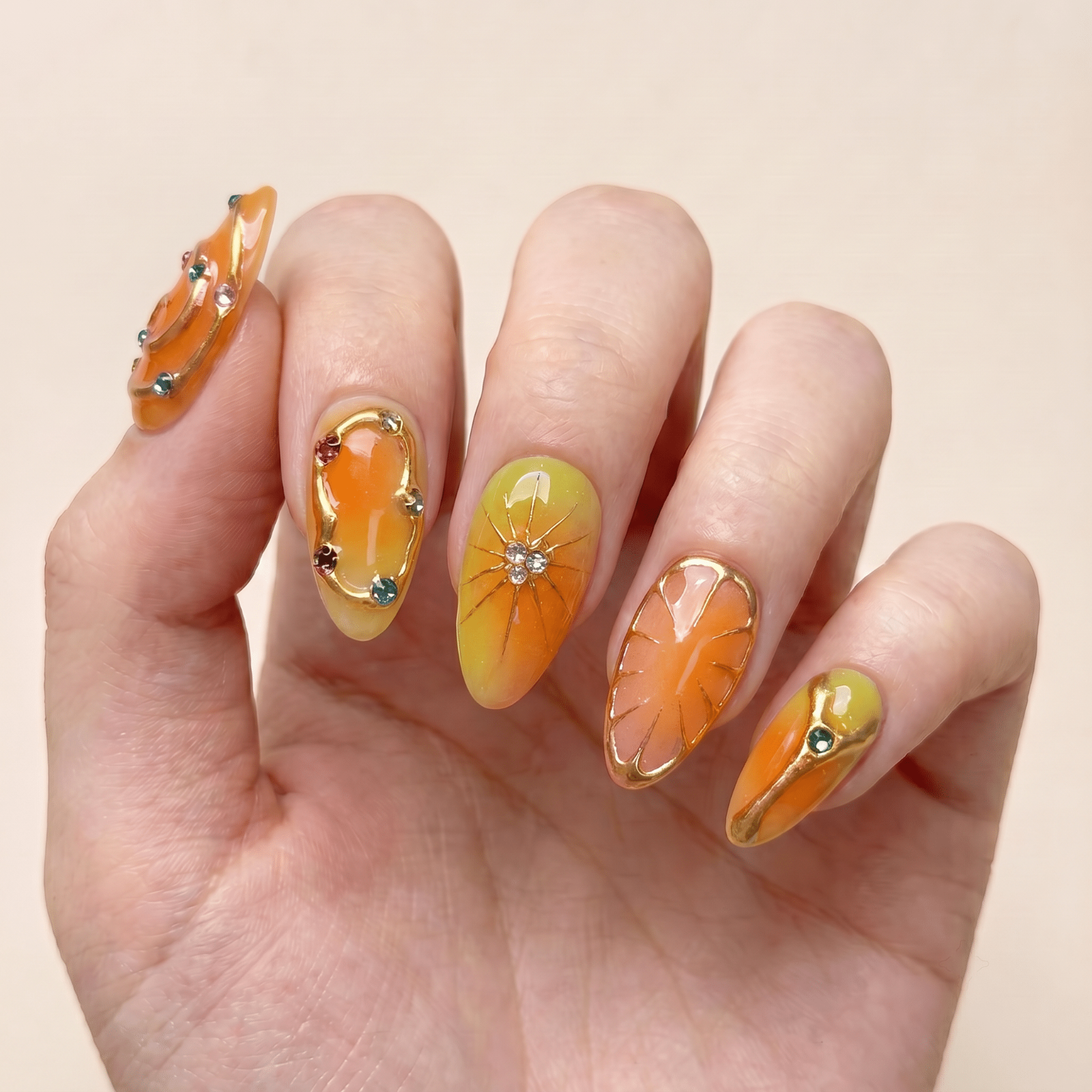 Orange summer press-on nails worn on hands by Nailsium