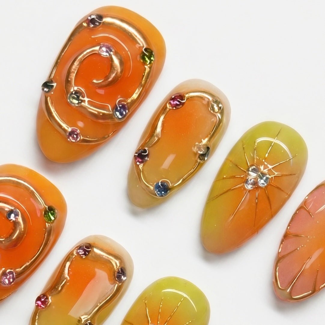 Hand painted citrus inspired press-on nails with gold details by Nailsium