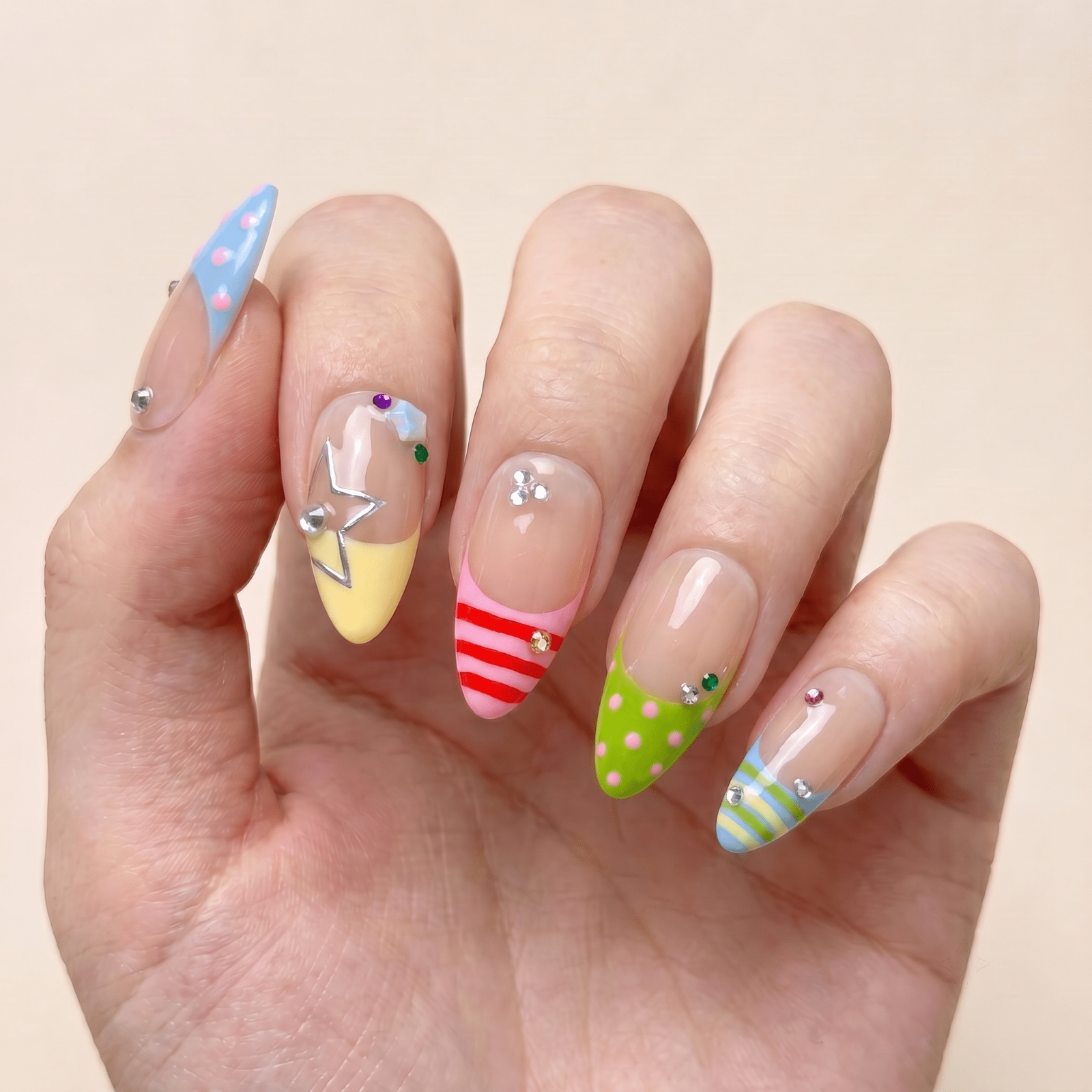 Colorful summer press-on nails worn on hands by Nailsium