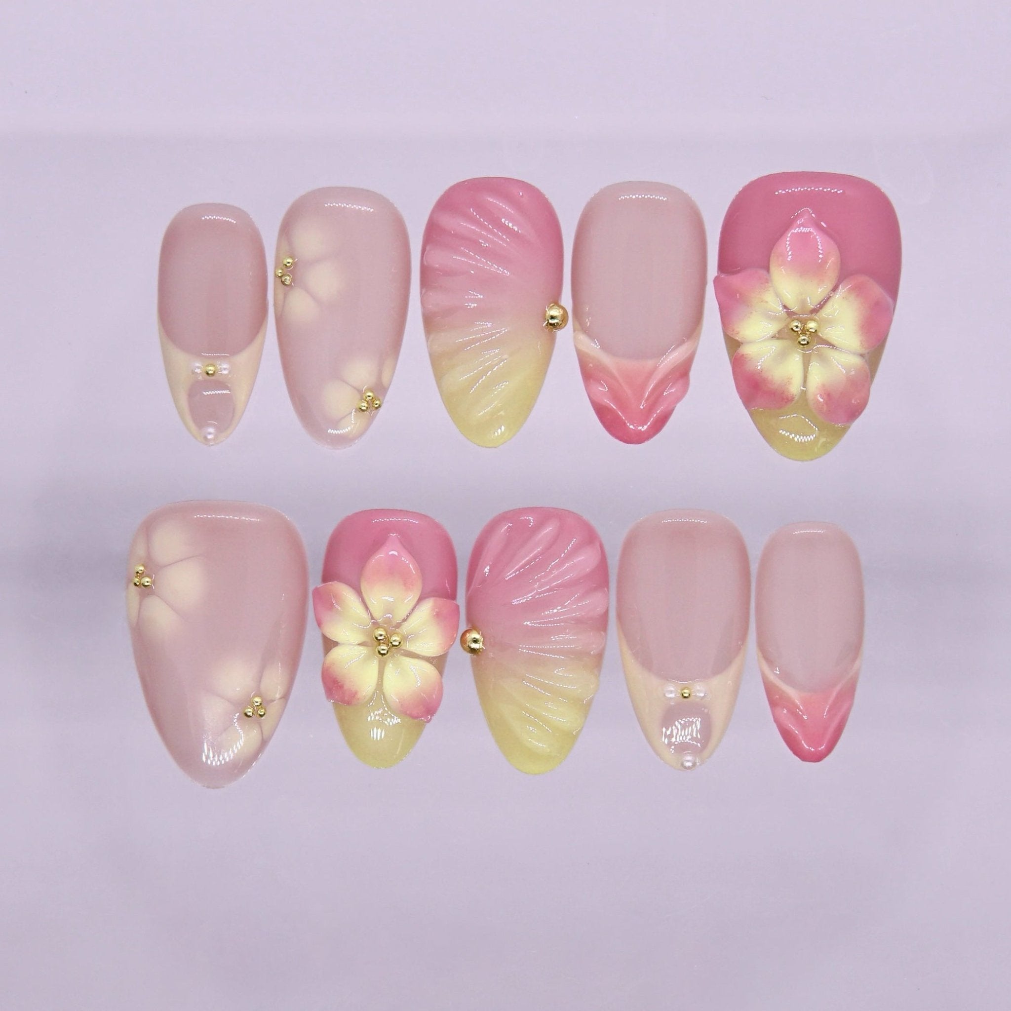 Pink and yellow press on nails with floral design and soft gradient tones