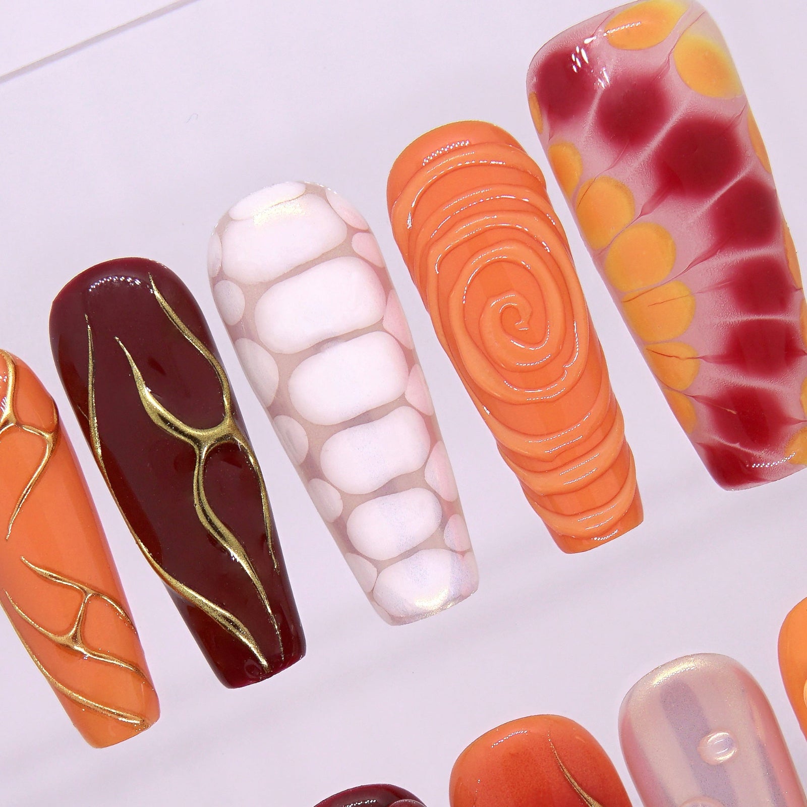 Macro shot of molten orange-gold ridges and transparent 3D gel droplets on Torrey Burn nails.