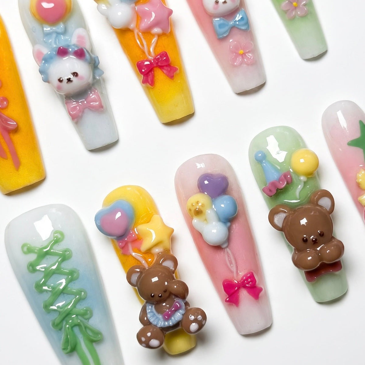 Yellow, pink, and green pastel gradient press-on nails with lace-up and star details.