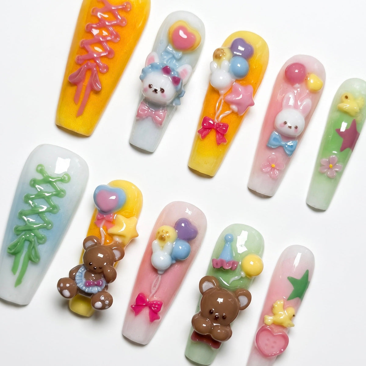 Close-up of 3D bunny and bear charms with colorful balloon accents on pastel press-on nails.