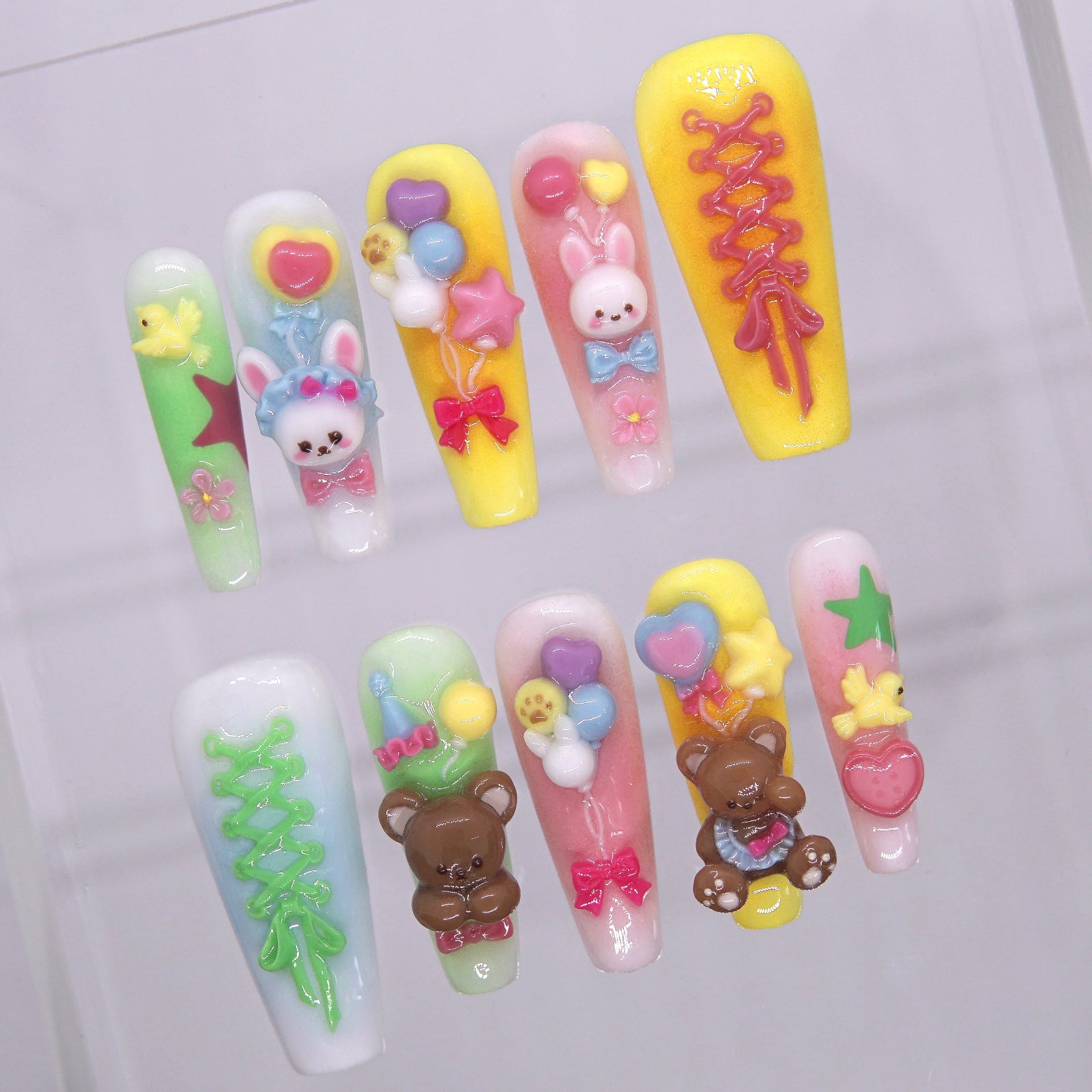 Close-up of 3D bunny and bear charms with colorful balloon accents on pastel press-on nails.