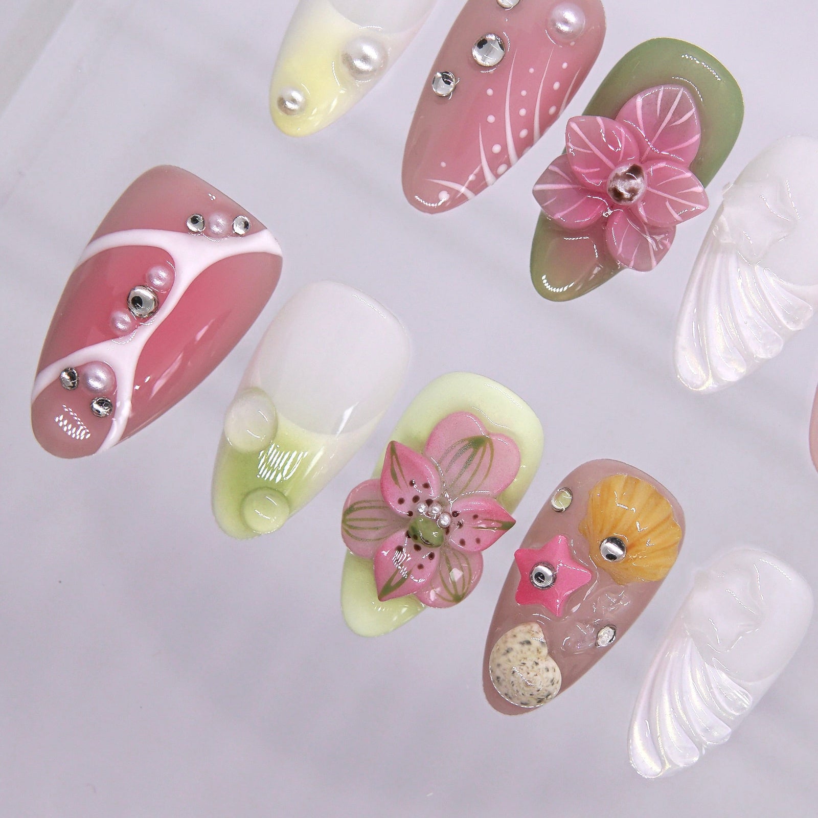 Shell, starfish, and sandy texture accents on tropical-inspired press-on nails.