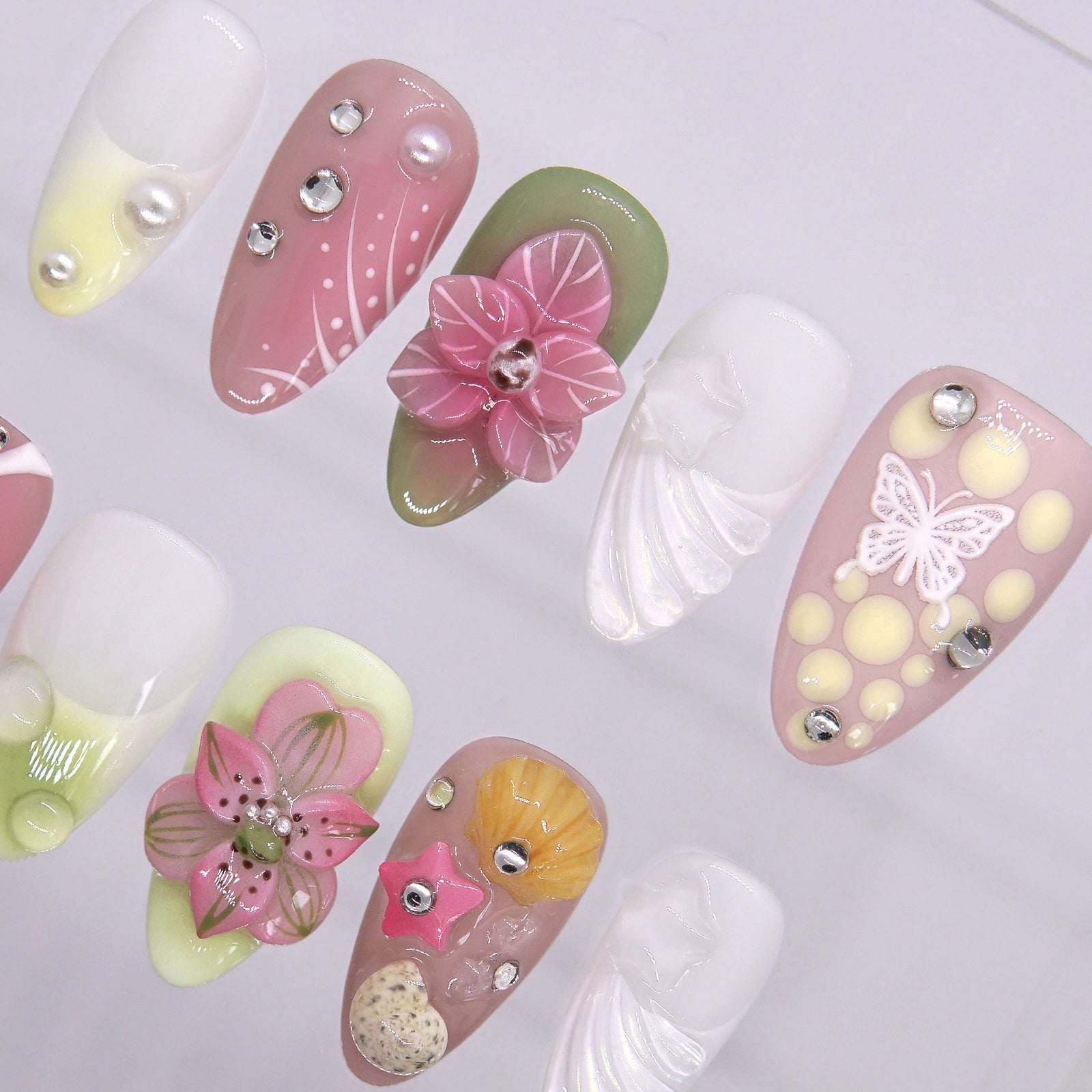 Shell, starfish, and sandy texture accents on tropical-inspired press-on nails.