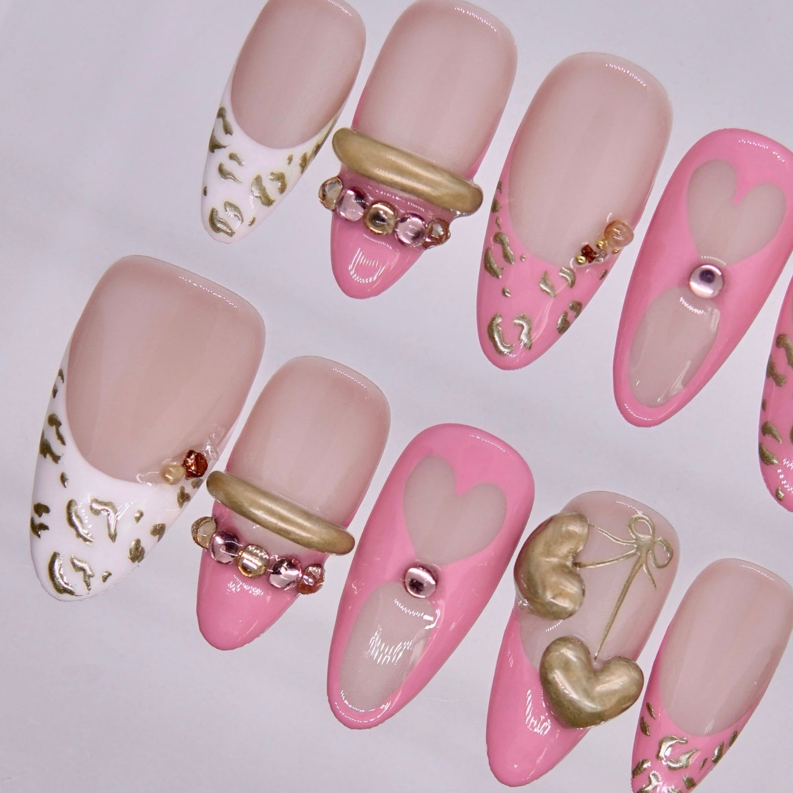 Detail view of Tiger zodiac Valentine nails with blush pink gradients, heart details, and gold embellishments.