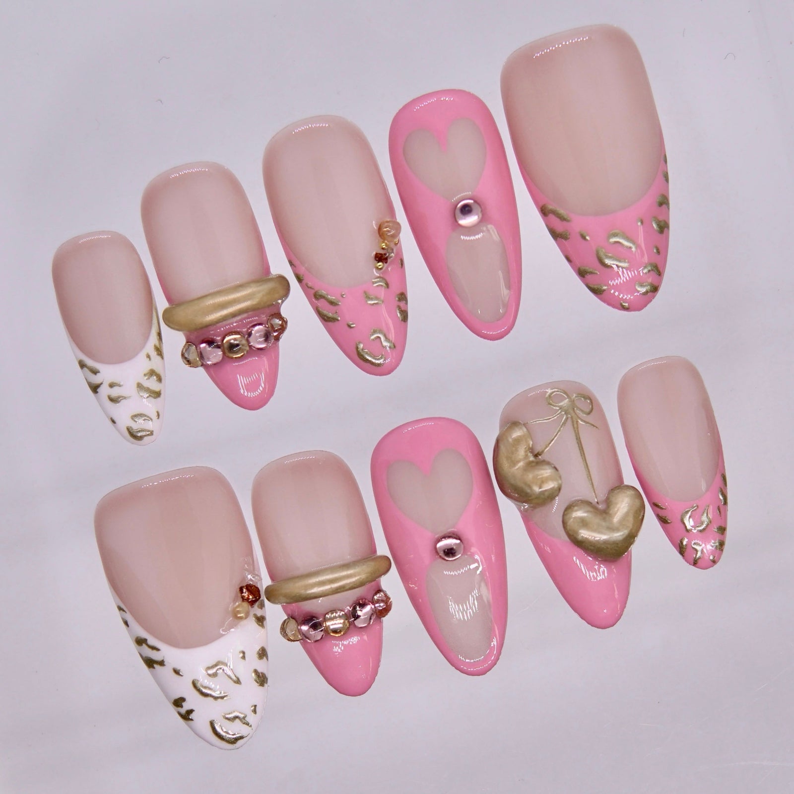 Close-up of Valor Tiger press-on nails showing gold sculptural accents and glossy nude finish.